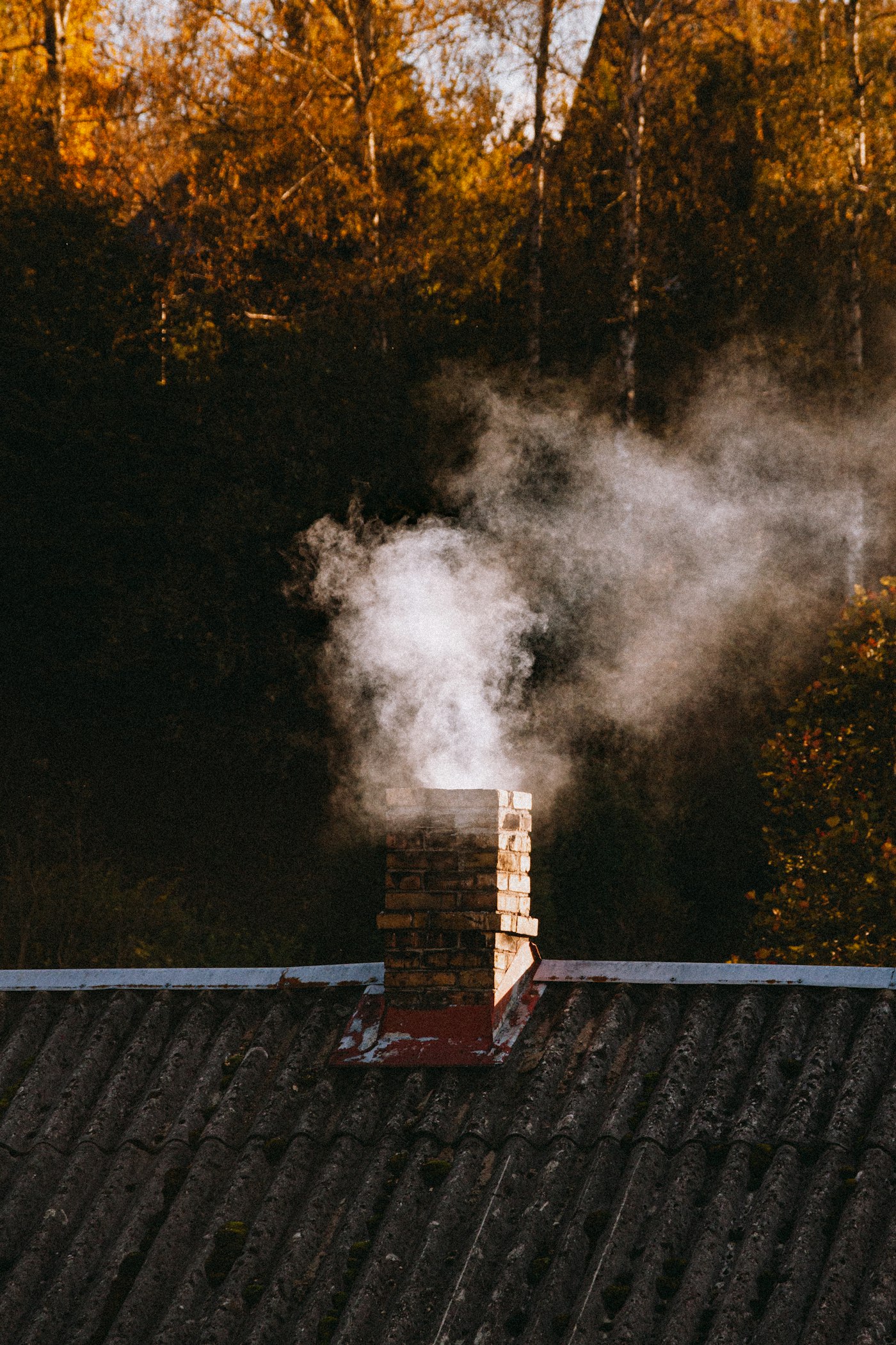 Smoke rising from a brick chimney